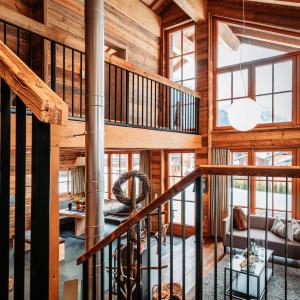 a staircase in a cabin with wooden walls and windows at IM WEIDACH Superior Chalets in Leutasch