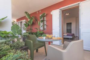 patio ze stołem, krzesłami i roślinami w obiekcie Casole Living B&B w mieście Copertino