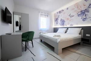 Dormitorio con cama, escritorio y TV en Marien Haus, en Karlovac