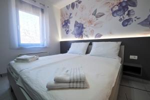 a bedroom with a bed with towels on it at Marien Haus in Karlovac +19 photos