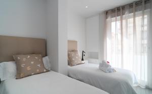 1 dormitorio con 2 camas con un animal de peluche encima en AAC Málaga - Apartamento luminoso y nuevo, a 1,3km del centro de Málaga en Málaga