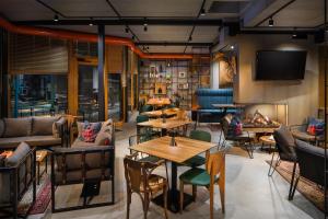 a restaurant with tables and chairs and a flat screen tv at Hotel COTA1110 in Beli Iskar