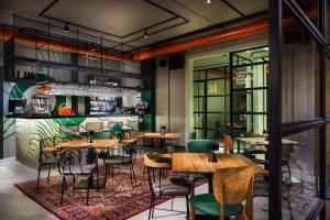 a restaurant with wooden tables and green chairs at Hotel COTA1110 in Beli Iskar