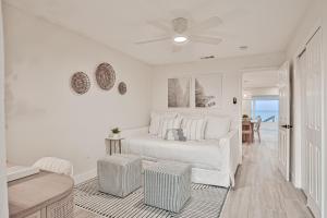 a white bedroom with a bed and a ceiling fan at Sunrise Beach Retreat in Flagler Beach