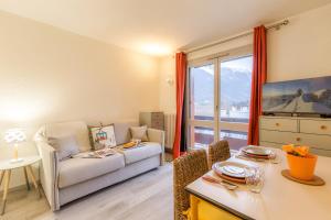 uma sala de estar com um sofá e uma mesa em Appartement des Périades - Happy Rentals em Chamonix-Mont-Blanc