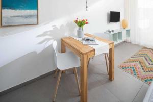 a wooden table and a white chair in a room at WestStrandBlick in Norderney