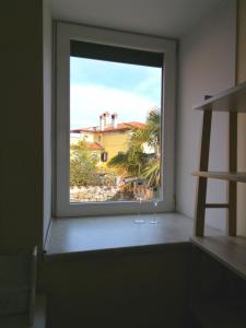 ein Fenster in einem Zimmer mit Blick auf ein Haus in der Unterkunft COZY CORNER in Koper