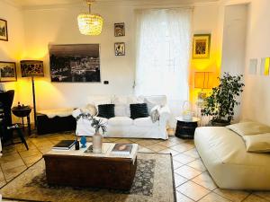 sala de estar con sofá blanco y mesa en Maison Fortune, en Castelnuovo del Garda