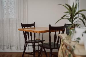 a table and chairs in a room with a plant at Hill Road Manor Bed & Breakfast in Grand Falls