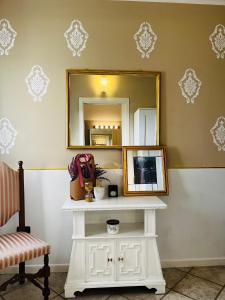 specchio e tavolo bianco in una stanza di Maison Fortune a Castelnuovo del Garda