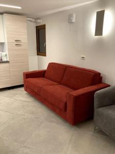 een rode bank in een woonkamer bij Appartamento Tre Archi con corte privata in Venetië