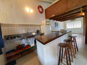 Una cocina con encimera y dos taburetes de bar. en Casa Vento Leste, en Ilhabela 10 fotos más
