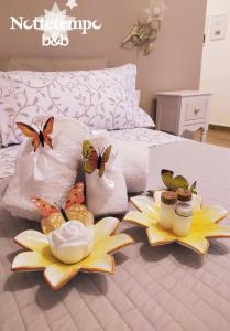 un letto con due piatti di cibo e farfalle sopra di B&B Nottetempo a Paupisi