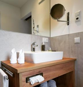 uma casa de banho com um lavatório e um espelho em Thurners Boutique Hotel em Bruck an der Grossglocknerstrasse