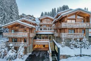 una casa de madera en invierno con nieve en el suelo en Ultima Courchevel Belvédère en Courchevel