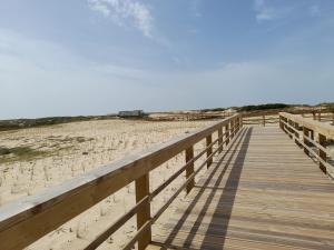 a wooden boardwalk leading to the beach at Casa Chanel in Figueira da Foz