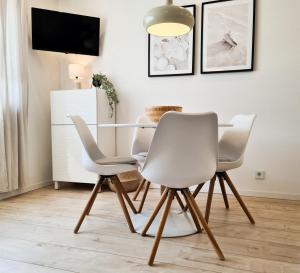 a dining room with white chairs and a table at Mirielle Apartments in Rust