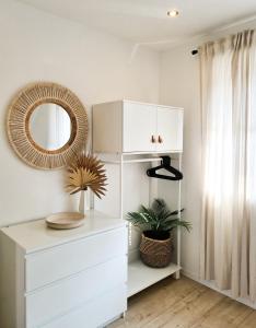 a white dresser in a room with a mirror at Mirielle Apartments in Rust