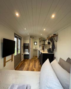 uma cozinha e uma sala de estar com uma cama num quarto em Luxury Shepherds Hut - The Moorhen by the lake em York