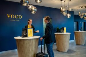 a man and a woman standing at a podium at voco Dusseldorf Seestern, an IHG Hotel in Düsseldorf