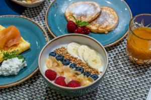 een tafel met borden ontbijtproducten met fruit bij voco Dusseldorf Seestern, an IHG Hotel in Düsseldorf