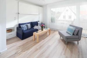 sala de estar con sofá azul y silla en 53 Nord, en Norderney