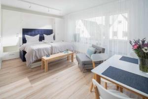 Dormitorio blanco con cama y mesa en 53 Nord, en Norderney