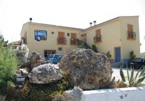 a large rock sitting in front of a building at Hostal El Arrecife in Sorbas
