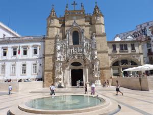 a building with a fountain in front of a church at Casa Chanel in Figueira da Foz