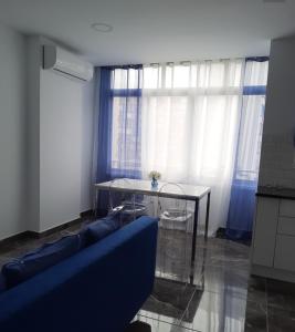 ein Wohnzimmer mit einem blauen Sofa und einem Tisch in der Unterkunft studio for rent in torremolinos -Málaga for vacations studio alquiler para vacationes, studio te huur voor vacantie Calle Río Mesa 5 in Torremolinos