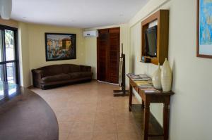 a living room with a couch and a television at Hotel Antibes in Natal