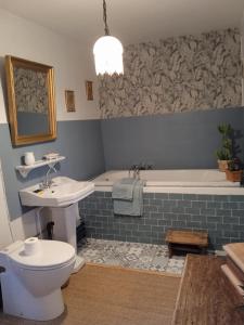 a bathroom with a tub and a toilet and a sink at Les Hortensias - Chambres d'hôtes in Saint-Antoine-de-Breuilh