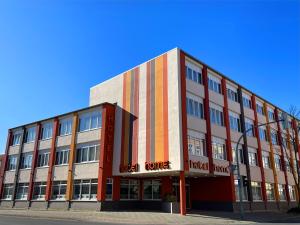 um edifício vermelho branco e laranja com uma casa adornada em home Hotel em Wilhelmshaven