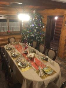 una mesa larga con un árbol de Navidad en una habitación en CABANA de POVESTE, en Suceviţa