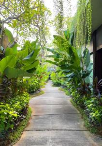 a walking path in a garden with green plants at Seminyak Icon - by Karaniya Experience - CHSE certified in Seminyak