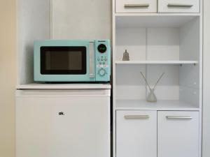 a microwave oven sitting on top of a white cabinet at Hotel Kaiser in Mönchengladbach