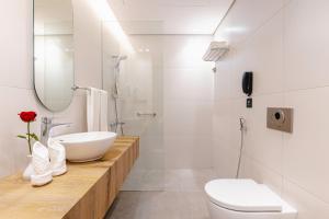 a white bathroom with a sink and a toilet at Assaafa Hotel in Al Madinah