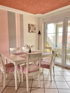 a white dining room table and chairs with a window at Ferienwohnung Pracht - großzügige FeWo ab 75 qm in Rust