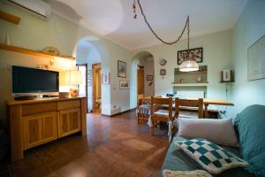 a living room with a television and a dining room at Appartamento Pomonte in Pomonte