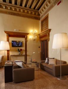 a living room with two couches and a table at Arcadia Boutique Hotel in Venice