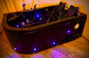 a black bath tub with lights in a bathroom at Mancini Shabby House in Rome