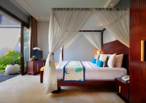 a bedroom with a bed with a canopy at Seminyak Icon - by Karaniya Experience - CHSE certified in Seminyak