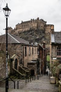 a castle on top of a hill with a street light at Greyfriars Studio Edinburgh in Edinburgh