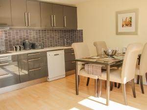 a kitchen with a table and chairs in a room at Coach House at Old Vicarage in Telford