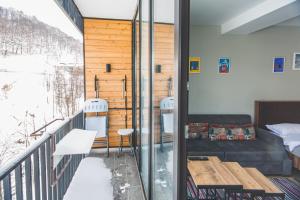 a balcony with a couch and a table at Perfect studio near Didveli ski area in Bakuriani