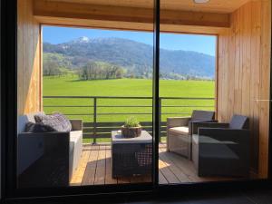 a screened in porch with a view of a green field at Gîte de charme avec jacuzzi #Calme #Cosy in Viuz-en-Sallaz