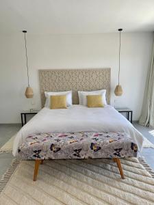 a bedroom with a large bed and two lamps at Lahô Lodge in Lalla Takerkoust