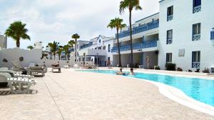 a swimming pool in front of a building at Aguazul - A pie de piscina y vistas al mar in Puerto del Carmen