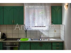 a kitchen with green cabinets and a sink and a window at Relaxing and luxurious apartment - All included - 100m beach - Zaton in Zaton