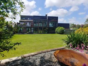 une maison avec une grande pelouse devant elle dans l'établissement Portreeves, à Arundel